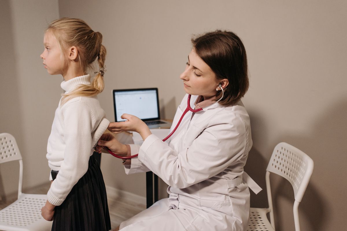 Pediatrician examining a child during a routine health checkup